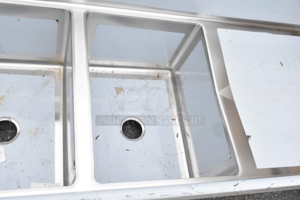 New Regency 600S31824224 stainless steel 3-bay sink with dual drain boards. Scratch and dent condition.