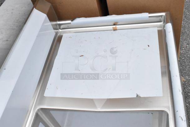 BRAND NEW Regency 600S31824224 stainless steel 3-bay sink with dual drain boards, minor scratches visible.