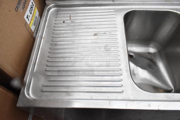 Stainless steel 3 bay bar sink with dual drain boards, visible drain, used condition, includes faucets and handles.