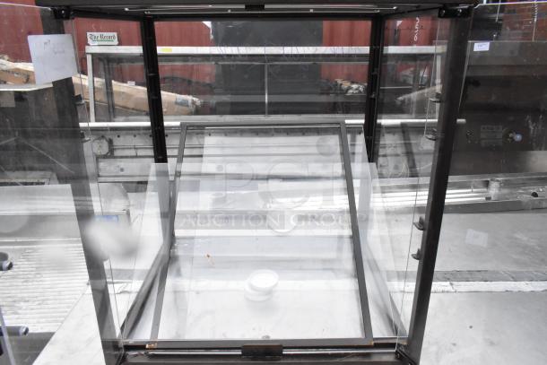 Metal countertop dry display case merchandiser with clear glass, black frame, and slight scratches. Features open front access.