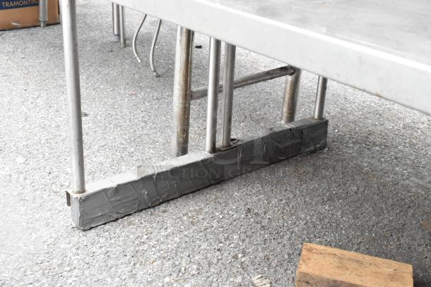 Stainless steel 2 tier overshelf, sturdy construction, with reinforced taped bottom support. Shows signs of outdoor use.
