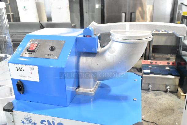 Brand new Carnival King 382SCM350R sno cone machine with metal design. 120 volts, 1 phase. Power and reset buttons visible.