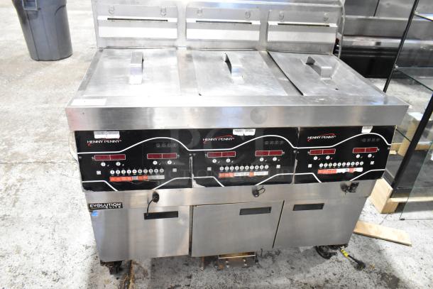 2016 Henny Penny EEG-243 FFFX ST stainless steel 3-bay deep fryer with filtration, lids, and casters. 225,000 BTU.