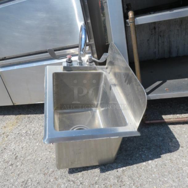Stainless steel hand sink with faucet and right side splash shield, dimensions 13x18.5x18, in good condition.