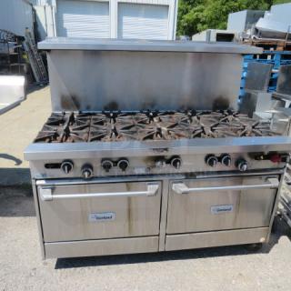 Garland 10-burner natural gas range with 2 racks, stainless steel overshelf, and casters. Used condition.