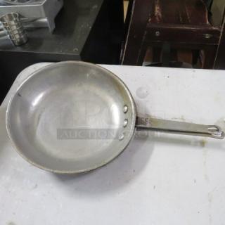 10.5-inch sauté pan with riveted handle, used condition, some surface wear, silver finish. No visible branding.