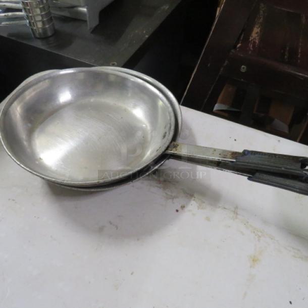 10.5-inch stainless steel sauté pan with a long handle, showing signs of wear. Ideal for versatile cooking needs.