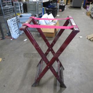 Wooden tray stand with red straps, foldable design, moderate wear. Ideal for hotel or home use. Model: 2XBID.