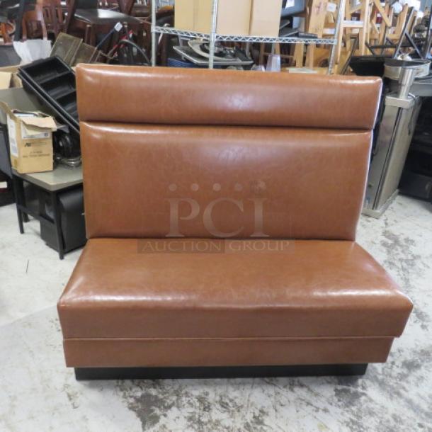 Single-sided brown cushioned booth, 48x25x45 inches. Features padded seat and backrest in good condition.