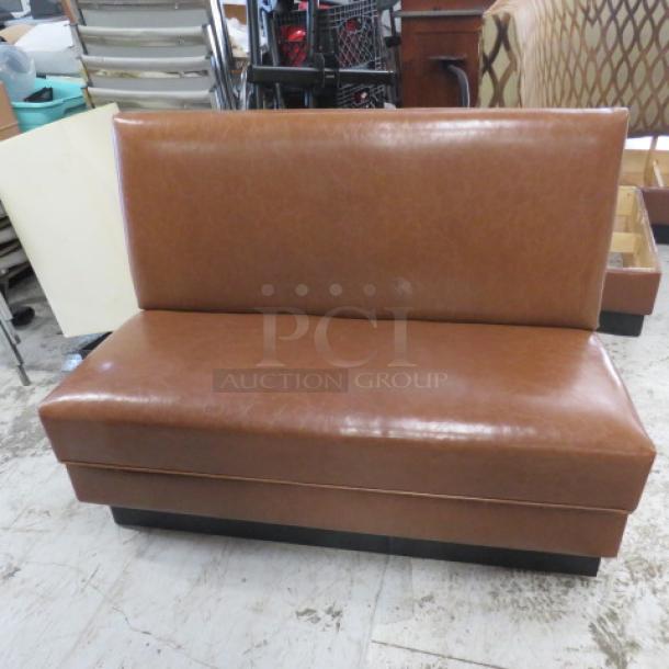 Single-sided brown cushioned booth, 48x25x36 inches, in good condition. Simple design with smooth leather finish.