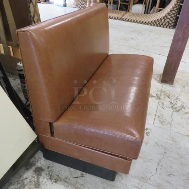 Brown cushioned booth, single-sided, 48x25x36 inches. Features durable upholstery, solid condition. Ideal for dining spaces.