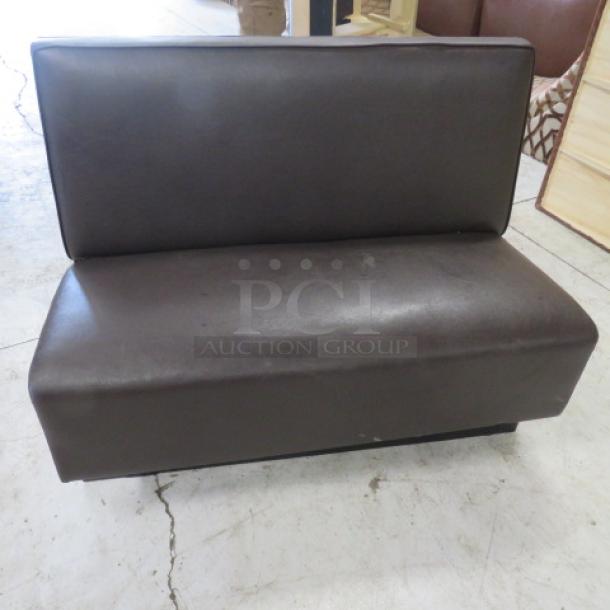 Single-sided chocolate brown cushioned booth, 48x26x36, in good condition. Smooth upholstery, ideal for restaurant seating.