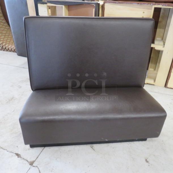 One single-sided chocolate brown cushioned booth, 48x27x45 inches, in good condition, with a sleek, smooth finish.