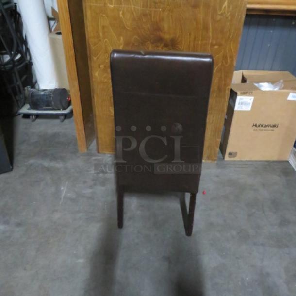 Brown cushioned high-backed chair with wooden legs, in good condition, shown from the back.