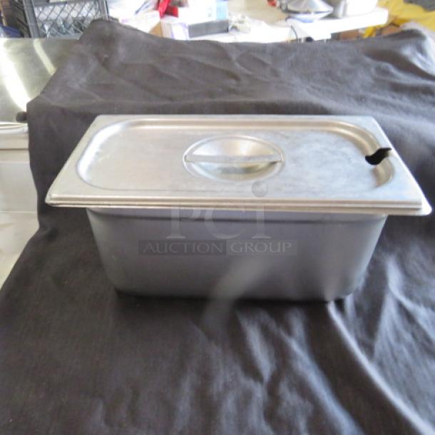 1/3 size hotel pan with lid, 6-inch deep, metal construction, slightly used. Perfect for food service settings.