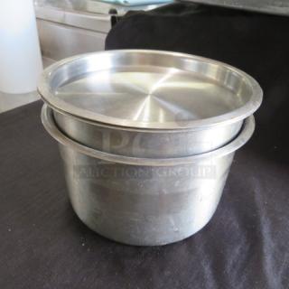 Stainless steel crock with lid, model 2XBID, in good condition, showing minor wear. Ideal for storage or cooking.