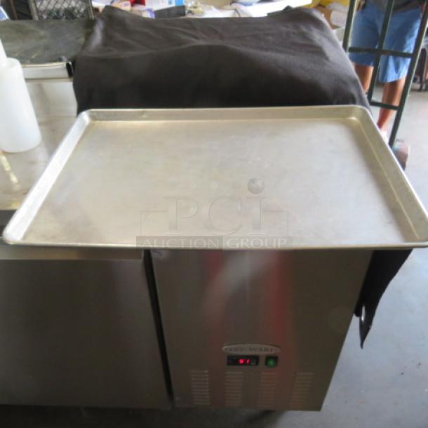 Full-size sheet pan on display, stainless steel, used condition, resting on a commercial appliance, labeled "5XBID."