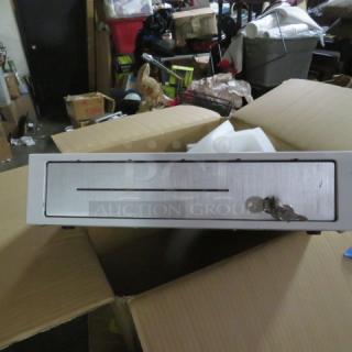 Clover cash drawer with key, silver front panel, slightly used condition, displayed in open cardboard box.