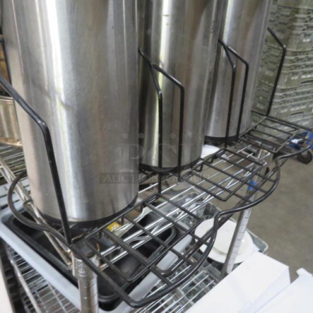 Black metal holder with three airpots; sturdy grid design, ideal for coffee service; minor wear; commercial use.