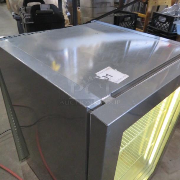 One working Red Bull glass door refrigerator, Model VC206484016, with 2 racks, removable stainless steel cover, 16x18x23 inches.
