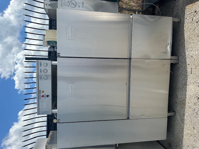 Commercial conveyor dishwasher showing belt-style continuous operation system