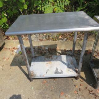Stainless steel table with under shelf, 36x24x35 inches. Used condition with visible wear. Suitable for kitchen or industrial use.