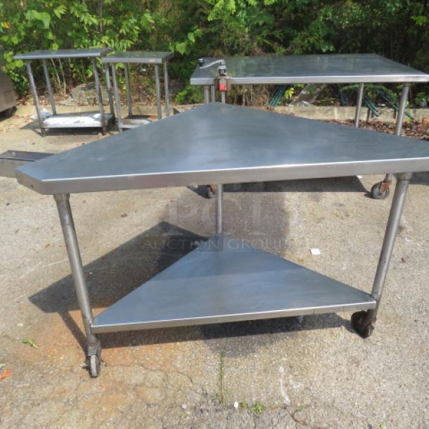 Stainless steel corner table with under shelf, 56x32x36, on casters, used condition. Ideal for commercial kitchen use.