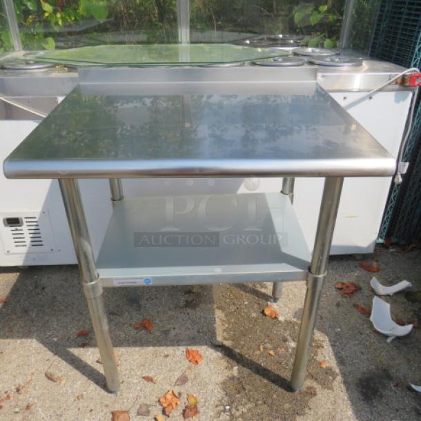 Stainless steel table with under shelf, 30x24x36 inches, polished finish, perfect for kitchen or workshop use.
