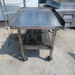 Stainless steel equipment table, 25x30x30 inches, with undershelf and casters, used condition, ideal for kitchen or workshop.