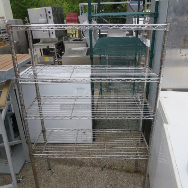 Metro shelving unit with four wire shelves, dimensions 36x14x55 inches, used condition, suitable for storage.