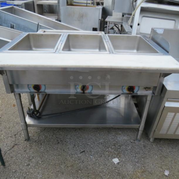 APW Wyott 3-well electric steam table with cutting board, stainless under shelf, on casters; 46x30x34 inches.