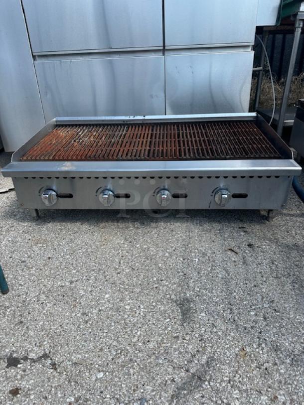 Natural gas charbroiler, 48x28x15 inches, stainless steel, four control knobs, used condition with rust on grill surface.
