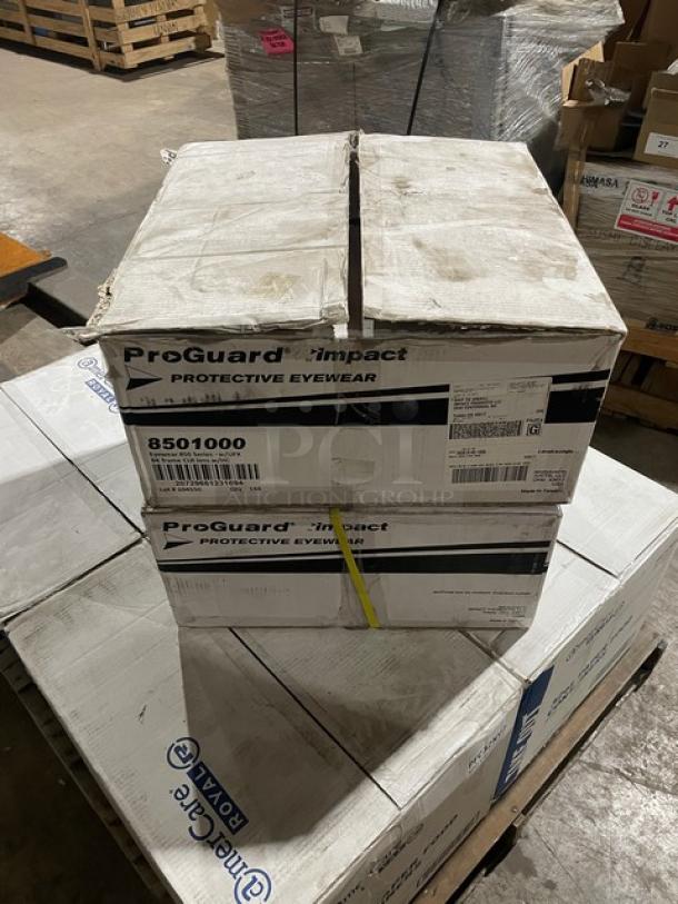 Boxes of ProGuard Model 8501000 clear protective eyewear with black frames, new in packaging, 144 per case.