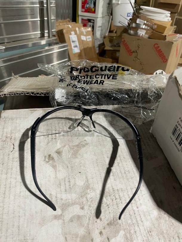 ProGuard 8501000 protective eyewear, black frame, brand new, clear lenses, 144 per case, packaging labeled "ProGuard Protective Eyewear."