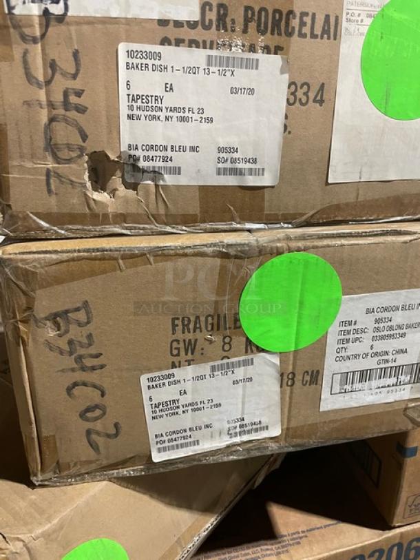 Mixed pallet with commercial items including Scott paper towels, eyewear, drink cups, serving platter, and holder. Boxes have green stickers and labels indicating fragile contents.