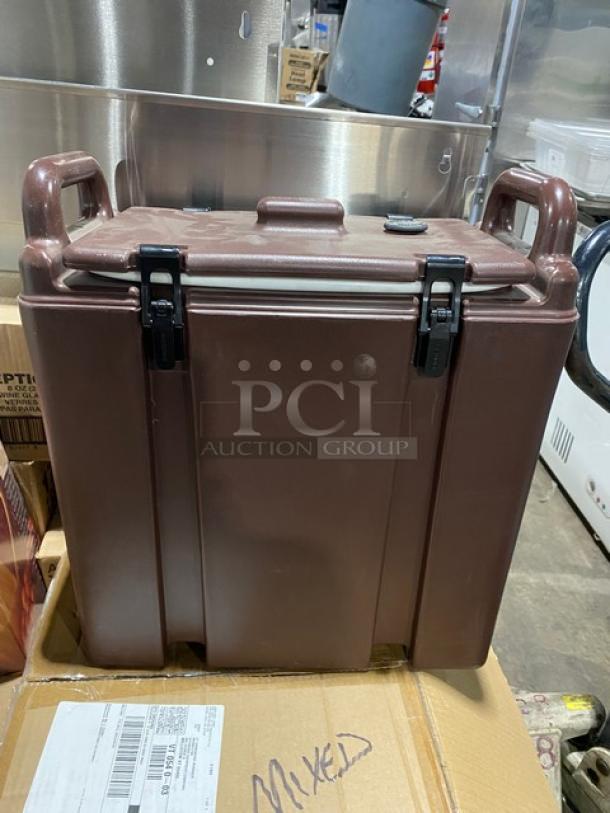 Brown storage container atop cardboard box labeled "Mixed," part of a mixed pallet auction. Perfect for bulk purchase.