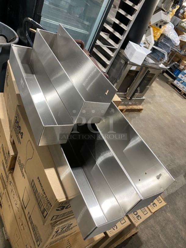 Brand new mixed pallet with stainless steel double bar speed rails atop boxed glassware and candles, including Arcoroc and Libbey models.