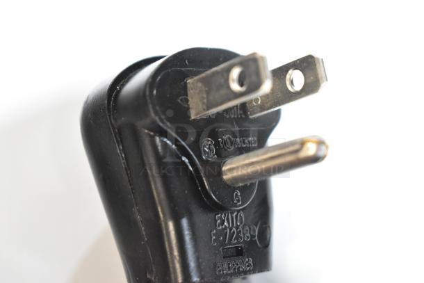 Close-up view of a black power plug with visible markings and labels indicating safety and certification details.