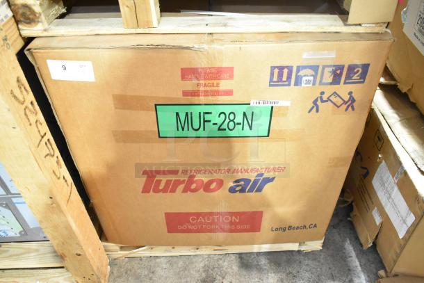Brand new Turbo Air MUF-28-N stainless steel undercounter freezer in box, 115V, 1 phase. Fragile handling labels visible.