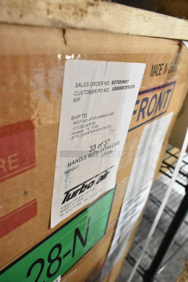Brand new Turbo Air MUF-28-N stainless steel commercial freezer in box, 115V, 1 phase. Shipping label details visible.