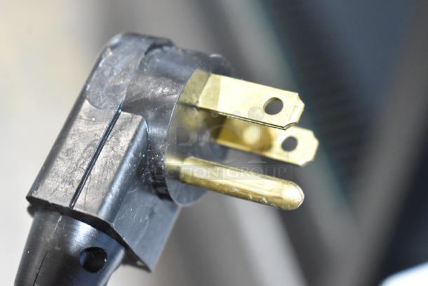 Close-up of a power plug for the Beverage Air SF34HC-B bottle cooler, showing a three-prong design.