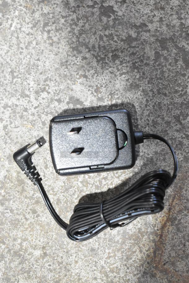 AvaTek 334PCS40 digital scale power adapter with cable on a concrete surface.