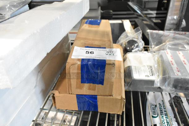 Boxes of new scratch and dent items, including a dough hook and paddle, marked with auction label "56 QTY VXZ".