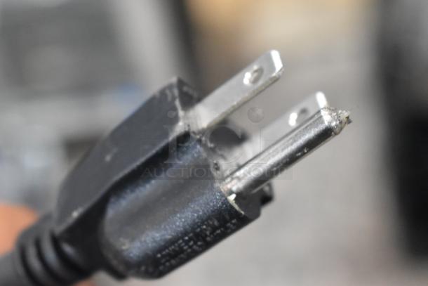 A close-up of a power plug from a Carnival King COLDREAM 2M beverage dispenser, showing minor wear on the prongs.