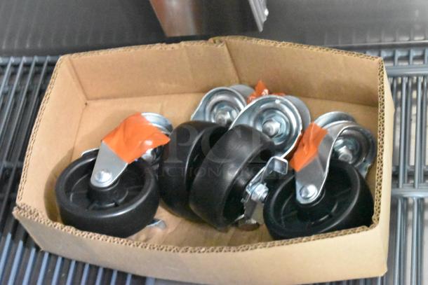 Box of commercial casters with black wheels and metal fittings, shown in cardboard packaging. Suitable for Avantco 447AP49R cooler.