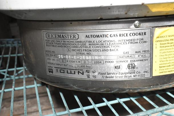 BRAND NEW RiceMaster RM-55N-R gas rice cooker, 110 cup capacity, 34,600 BTU. Labels show model, input rating, and certification marks.