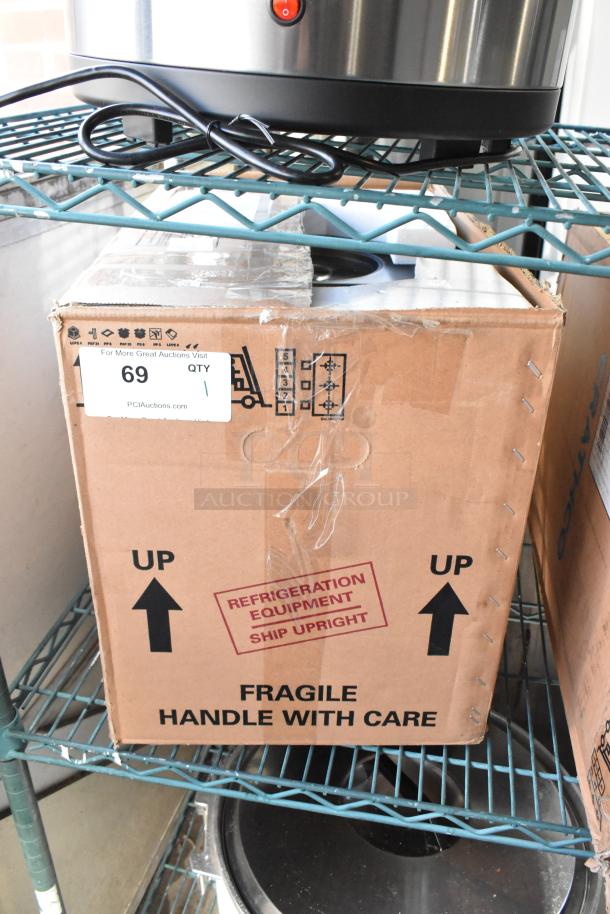 Brand new Crathco D25-4 beverage dispenser base in original box. High impact plastic, 120V, 1 Phase. Labels indicate "Fragile" and "Refrigeration Equipment."