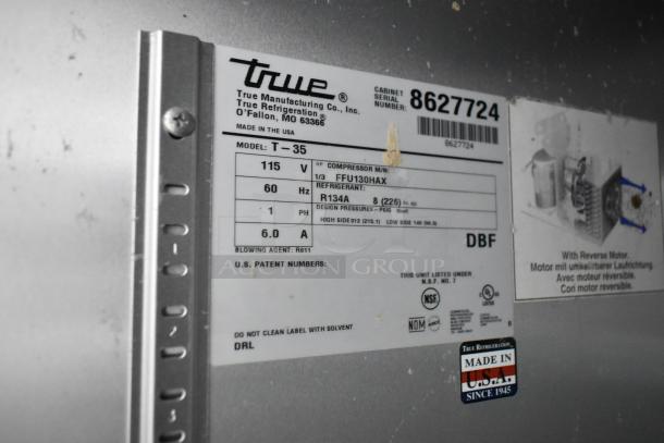 Label on True T-35 cooler showing model, voltage, refrigerant, and manufacturing details. Made in USA sticker present.