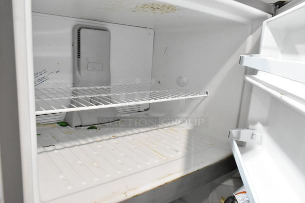 2022 Whirlpool WRT311FZDM02 stainless steel fridge with freezer. Interior has shelving. Visible wear marks. 115V, 1 phase.