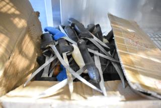 Box of 40 sharpened stainless steel knives with various handle colors, including a fillet knife, partially exposed and arranged chaotically.